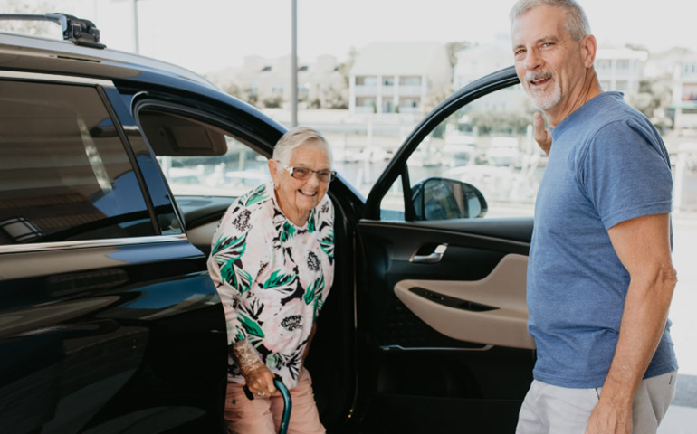 Man holding car door for a woman